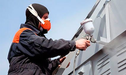 Proacero trabajador pintando una pared de acero